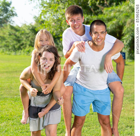 Parents piggybacking children 85968268