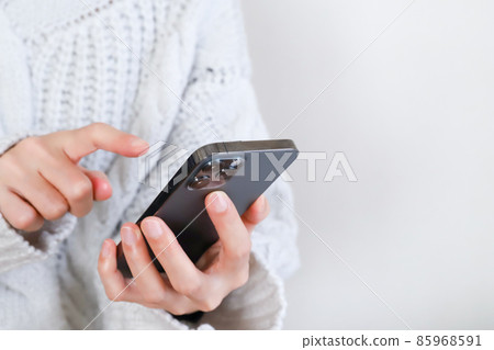 Hand of a woman touching a smartphone 85968591