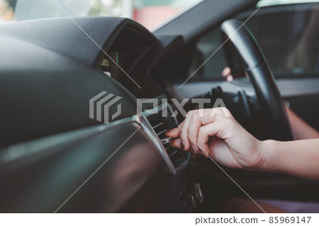 Driver adjusting a vehicle climate air conditioner. Driver adjusting a vehicle climate air conditioner. 85969147