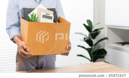 Resignation Concept The male standing and using his hands lifting a box of his stuff Resignation Concept The male standing and using his hands lifting a box of his stuff 85972837