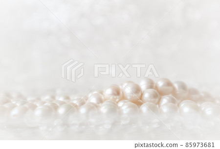 Nature white string of pearls on a sparkling background in soft focus, with highlights 85973681
