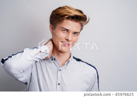 handsome young guy wearing shirt while looking at camera and smiling. Stylish man's hairstyle. handsome young guy wearing shirt while looking at camera and smiling. Stylish man's hairstyle. 85976625