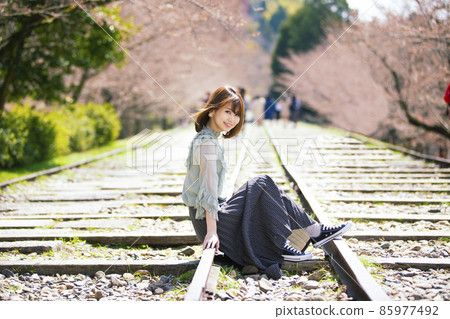 A young woman sitting on a railroad track against the backdrop of cherry blossoms at Keage Incline in Higashiyama Ward, Kyoto City, Kyoto Prefecture A young woman sitting on a railroad track against the backdrop of cherry blossoms at Keage Incline in Higashiyama Ward, Kyoto City, Kyoto Prefecture 85977492