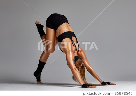 Portrait of female anger, animal instinct, demonstrating their incredible flexibility with the movement of animal flow in the studio on a gray background. Portrait of female anger, animal instinct, demonstrating their incredible flexibility with the movement of animal flow in the studio on a gray background. 85978545