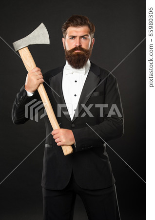 he looks brutal. Brutal gentleman holding axe. Bearded man 85980306