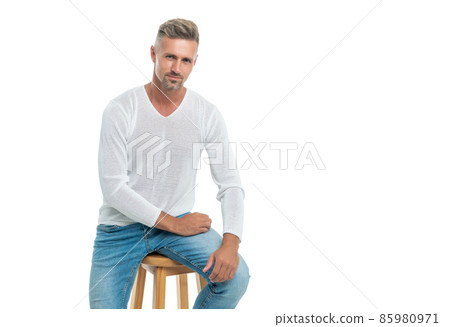 smiling handsome mature guy with graying hair sit on chair isolated on white, mens beauty. smiling handsome mature guy with graying hair sit on chair isolated on white, mens beauty. 85980971