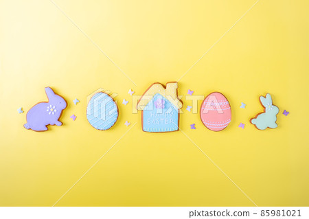 Happy Easter. Multicolored pastel easter cookies on a yellow background, various gingerbread glazed cookies , flat lay, view from above, blank space for greeting text, banner, flyer, coupon. Happy Easter. Multicolored pastel easter cookies on a yellow background, various gingerbread glazed cookies , flat lay, view from above, blank space for greeting text, banner, flyer, coupon. 85981021