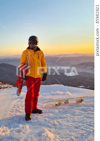 Silhouette of Snowboarder walking on snowy powder near fir-tree forest covered with snow. 85981921
