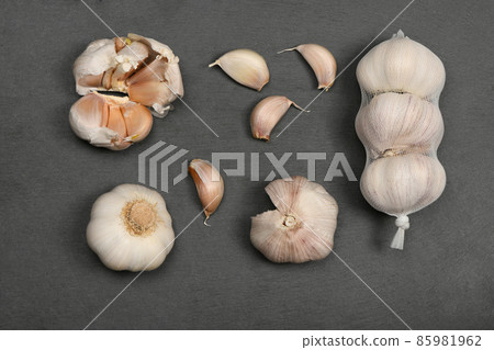 Garlic isolated on black stone background. 85981962
