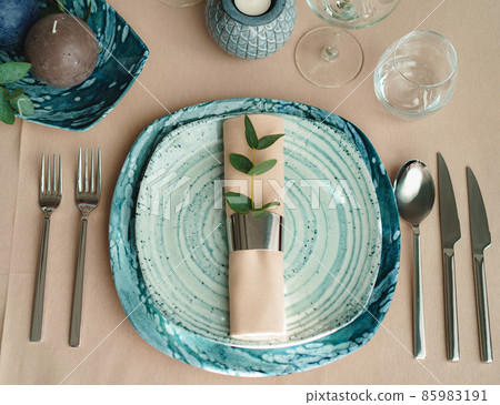 Luxury green table setting decorated with candles Luxury green table setting decorated with candles 85983191