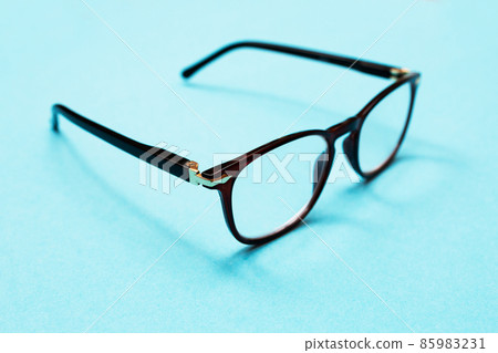 Glasses for vision on a blue background. Bad vision concept. Take care of your eyesight. Glasses for vision on a blue background. Bad vision concept. Take care of your eyesight. 85983231