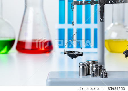 Laboratory scales with weights against test tubes 85983360