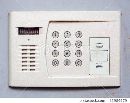 White metal intercom on a light gray wall. Close-up photo White metal intercom on a light gray wall. Close-up photo 85984279