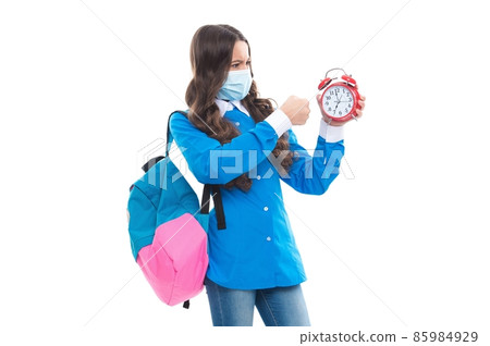 Angry school child in face mask punch alarm clock during COVID-19 disease pandemic, ultimatum Angry school child in face mask punch alarm clock during COVID-19 disease pandemic, ultimatum 85984929