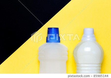 Mockup cleaning detergent in a bottle on a bright yellow black background with copy space. Household chemicals for sanitation and housework. Packaging for goods top view 85985144