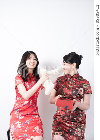 Intimate interaction between mother and daughter wearing cheongsam Intimate interaction between mother and daughter wearing cheongsam 85985412