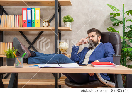 Relax and unwind. Serious employee relax with legs on desk. Rest break in office. Relaxation 85985544