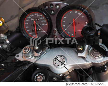 The instrument panel with two circular speedometers is located on the handlebars of the motorcycle. Closeup photo 85985550