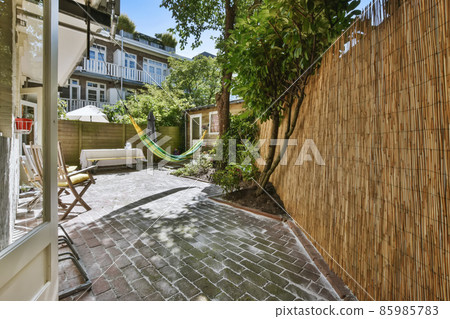 Spectacular courtyard of the house with hammock and trees Spectacular courtyard of the house with hammock and trees 85985783