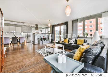 Lovely living room with black sofa and yellow pillows Lovely living room with black sofa and yellow pillows 85985830