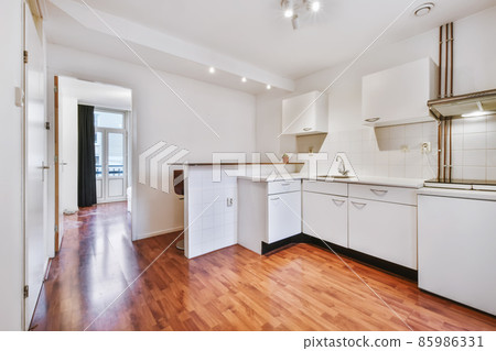 Minimalist kitchen with a snow-white kitchen set and wooden floor Minimalist kitchen with a snow-white kitchen set and wooden floor 85986331