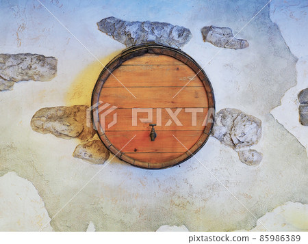 Wooden round barrel with a tap in the wall with decorative plaster 85986389