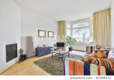 Attractive living room with a bright sofa and soft carpet 85986472