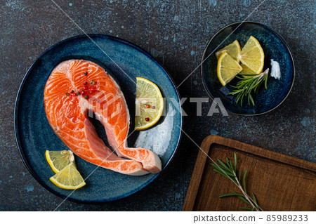 Raw fresh fish salmon steak top view on plate rustic dark concrete stone background 85989233