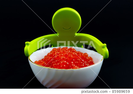 Toy man with bowl red caviar Toy man with bowl red caviar 85989659