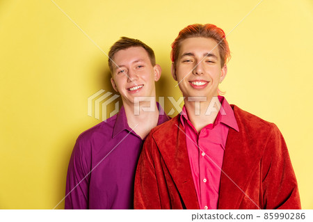 Portrait of young men, couple posing isolated on yellow background. Valentine's day celebration. Concept of emotions, love, relations, romantic Portrait of young men, couple posing isolated on yellow background. Valentine's day celebration. Concept of emotions, love, relations, romantic 85990286