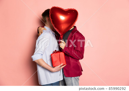 Happy couple holding balloons shaped hearts. Valentine's day celebration. Concept of emotions, facial expression, love, relations, romantic holidays. 85990292