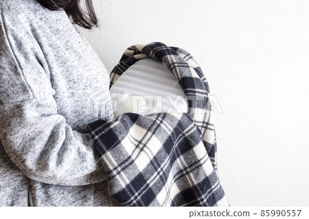 A woman holding a hot water bottle A woman holding a hot water bottle 85990557