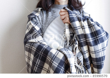A woman holding a hot water bottle 85990570