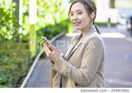 A woman who stops and checks information on her smartphone A woman who stops and checks information on her smartphone 85991060