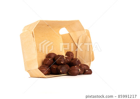 Peeled hazelnuts from a cardboard box on a white background. 85991217