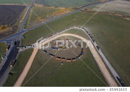 Reception of sugar beets at a sugar factory. The queue of trucks at the reception of beets at the factory. Aerial shooting. Reception of sugar beets at a sugar factory. The queue of trucks at the reception of beets at the factory. Aerial shooting. 85991633
