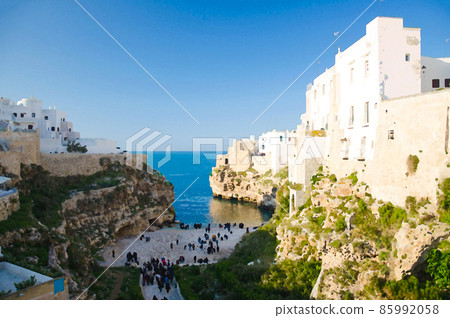 Watercolor drawing of Polignano a mare town with beach lama monachile cala porto and white buildings on grottos and cliffs in Puglia Apulia 85992058