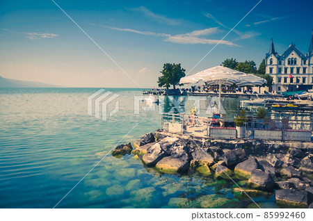 Watercolor drawing of View of Vevey-Marche and outdoor cafe umbrellas and tables on stone shore of Lake Leman Lake Geneva in Vevey 85992460