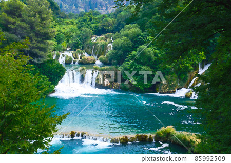 Watercolor drawing of Beautiful river waterfalls among green plants, trees and forests In Krka National Park, Dalmatia, Croatia Watercolor drawing of Beautiful river waterfalls among green plants, trees and forests In Krka National Park, Dalmatia, Croatia 85992509