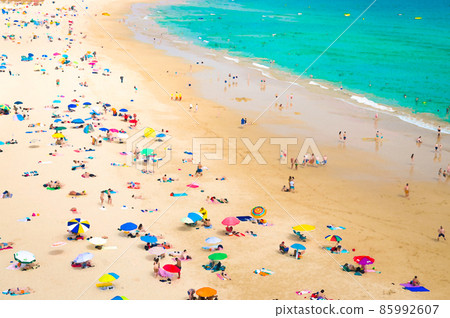 Watercolor drawing of Portimao Praia de Rocha beach with tourists and colourful umbrellas, Algarve 85992607