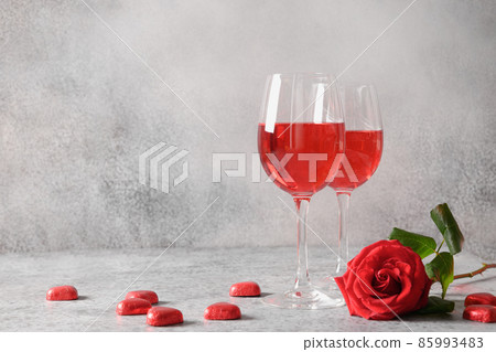 Two wine glasses with red wine for romantic dating or Valentine's day dinner with red rose. Two wine glasses with red wine for romantic dating or Valentine's day dinner with red rose. 85993483