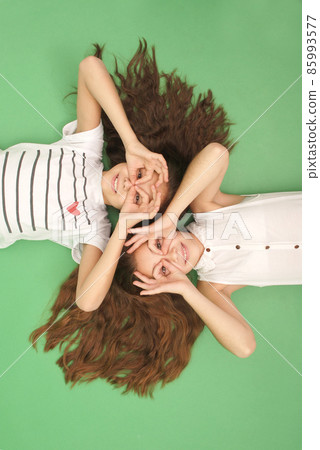 Funny portrait of two young girls with long hair 85993577