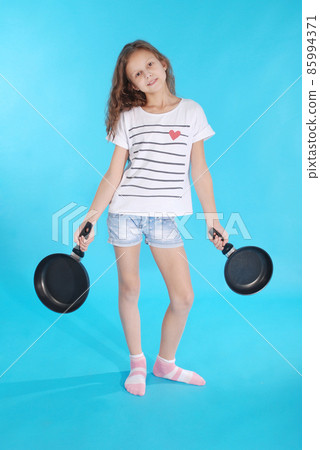 Young girl with a frying pan Young girl with a frying pan 85994371