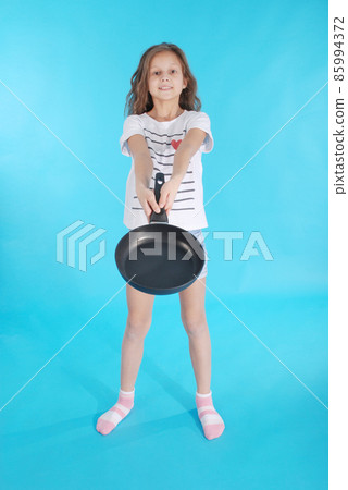 Young girl with a frying pan Young girl with a frying pan 85994372