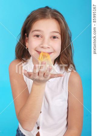 Young girl playing with chewing gum Young girl playing with chewing gum 85995167