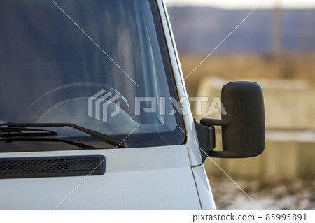 Close up of side rear-view mirror on a modern car 85995891
