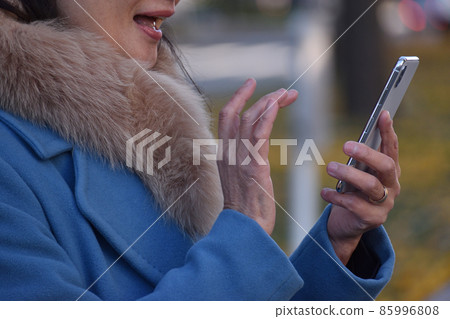 穿外套和操作手機的資深婦女 穿外套和操作手機的資深婦女 85996808