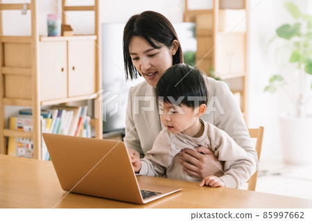 A mother who balances remote work and childcare A mother who balances remote work and childcare 85997662
