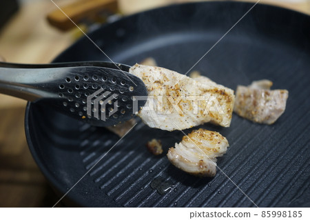 Scene of picking up cooked sous vide whole neck with tongs Scene of picking up cooked sous vide whole neck with tongs 85998185