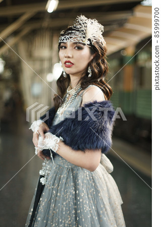 Retro vintage portrait of beautiful Gatsby woman stand look around, wait coming train for lover Retro vintage portrait of beautiful Gatsby woman stand look around, wait coming train for lover 85999700